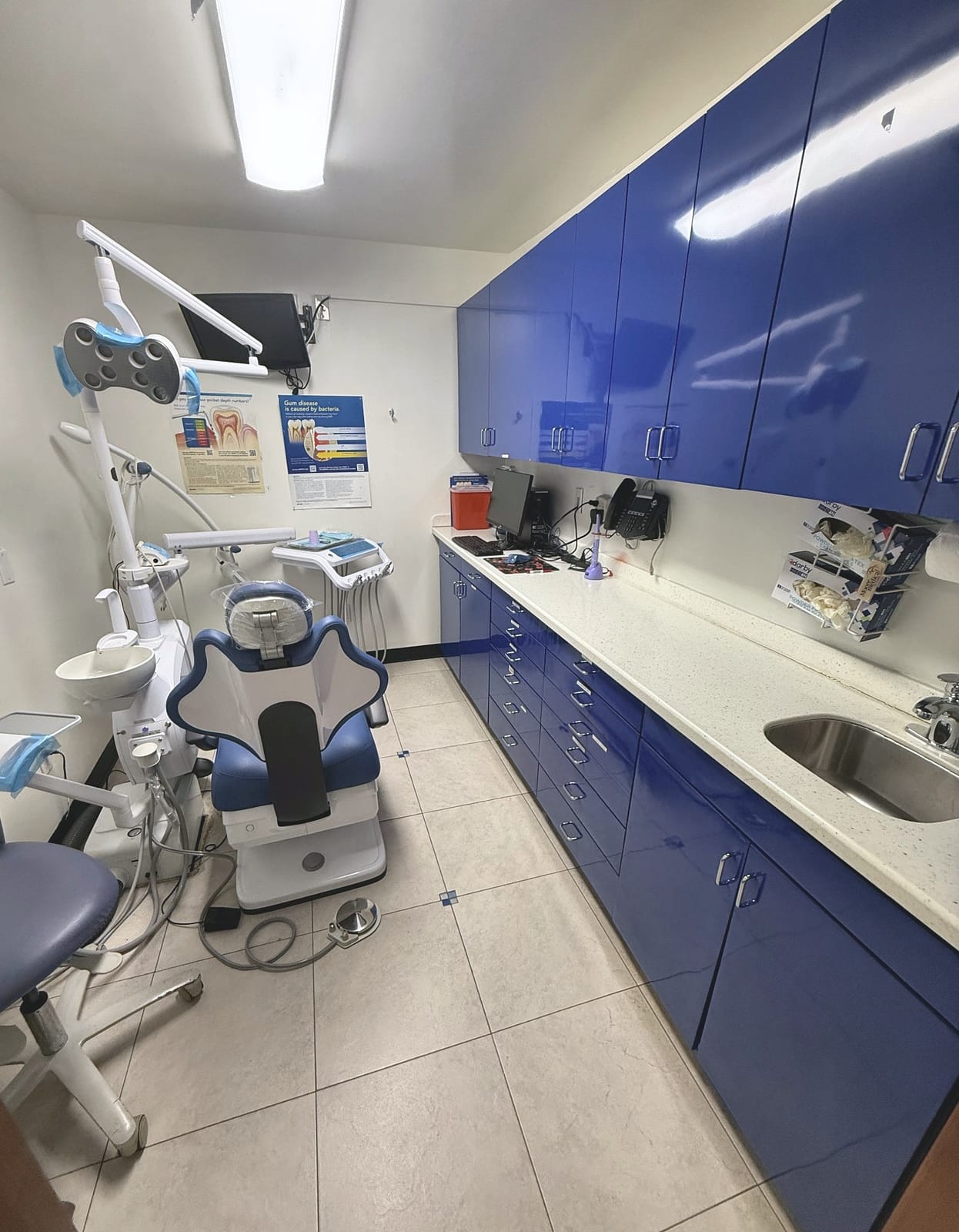 Treatment room with blue cabinets and a dental chair